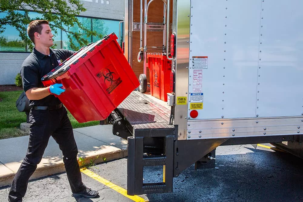 MedPro Disposal team member loading a medical waste container